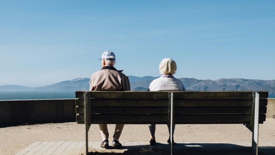 Couple de retraités assis sur un banc face à la mer