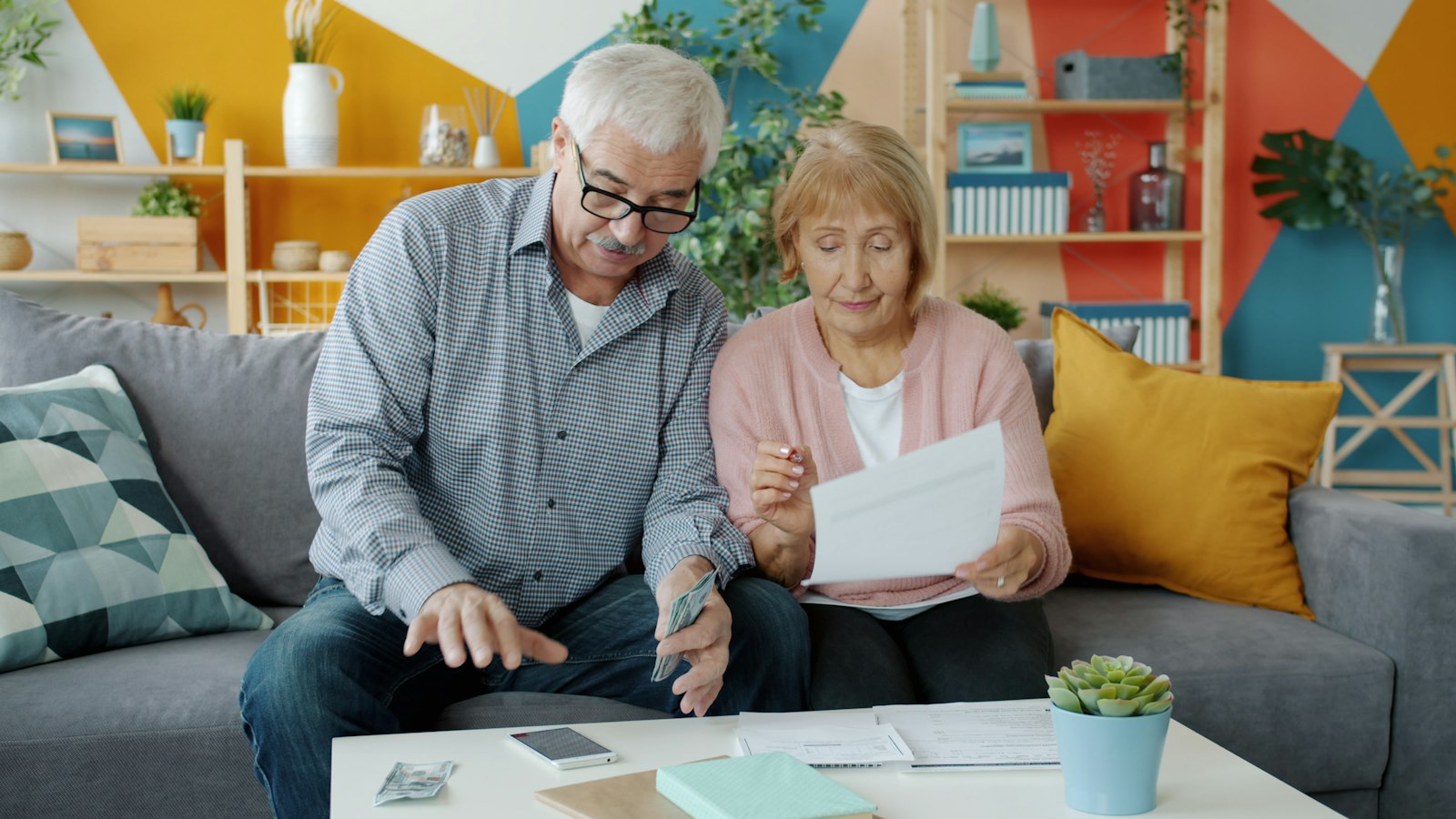 Couple de seniors examinant leurs documents de retraite à domicile